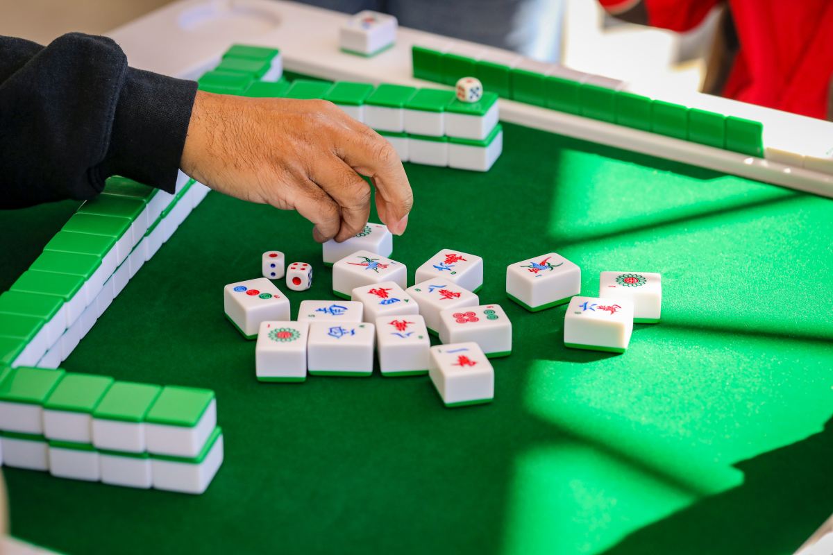 Mahjong tiles in play on a green table